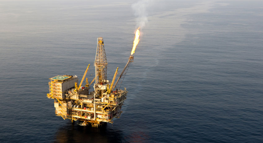 aerial photo of a large offshore oil rig with a gas flare