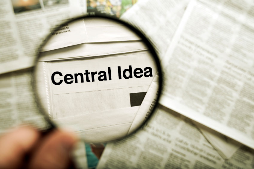 magnifying glass over a newspaper with the words 'central idea' magnified