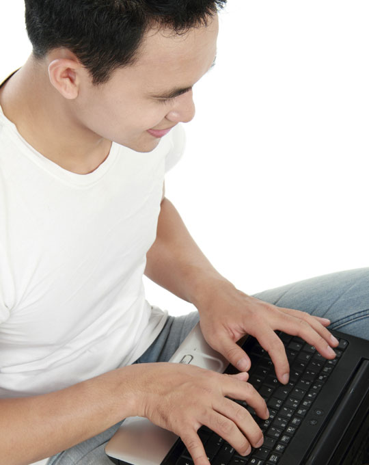 student typing on a laptop