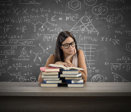 Mathematical  and scientific expressions are shown on a chalkboard behind a student  reading from a book