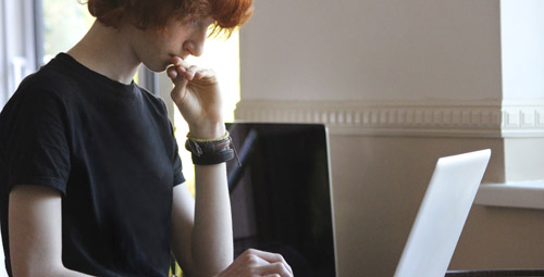 student reading from a laptop computer